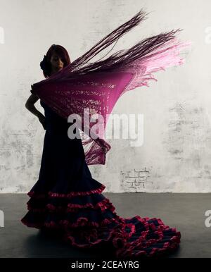 Ballerina di flamenco in azione con il tipico costume da ballo spagnolo. Velocità e movimento elevati. Foto Stock