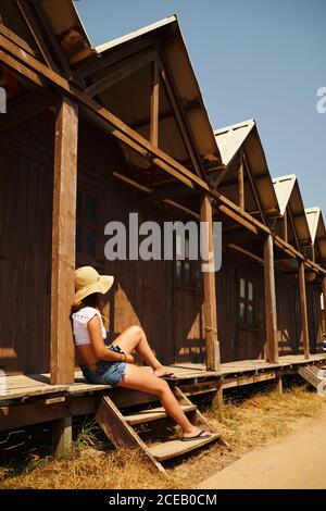 Donna turistica appoggiata su un edificio in legno Foto Stock