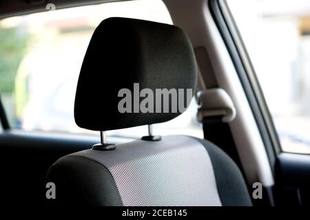 Cuscino per la testa del sedile del conducente con rivestimento nero all'interno di auto moderna di giorno Foto Stock