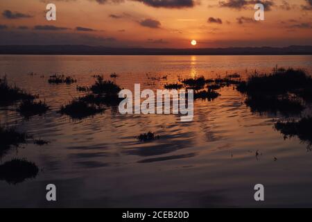 Lago sotto il cielo del tramonto Foto Stock