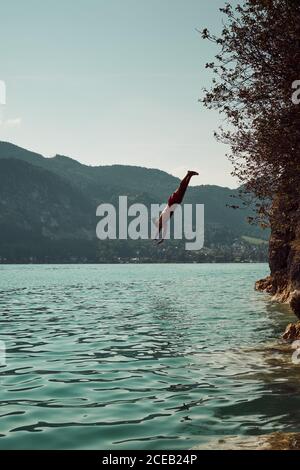 uomo che salta in acqua Foto Stock