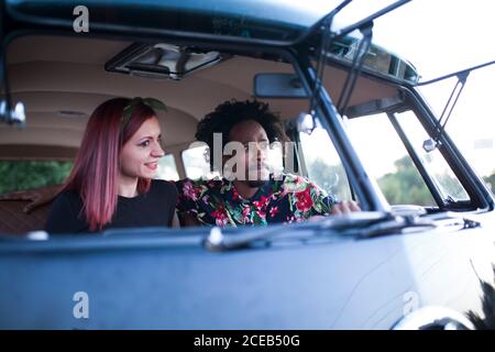 bella afro uomo gode il viaggio nel suo van vintage con alcuni amici Foto Stock