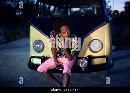 bella afro uomo gode il viaggio nel suo van vintage con alcuni amici Foto Stock