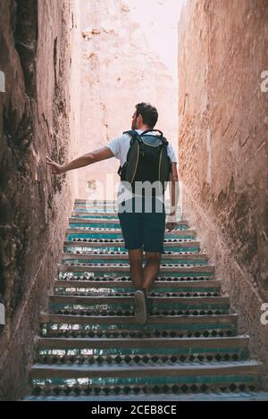 uomo che cammina sulle scale attraverso le pareti di argilla a marrakech