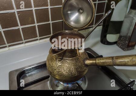 primo piano vista di bronzo cezve su gas-stufa che usava per preparare il caffè Foto Stock