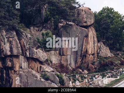 bella scogliera rocciosa coperta di alberi in giorno nuvoloso Foto Stock