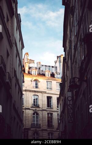 Dal basso si possono ammirare edifici vicini l'uno all'altro Sotto il cielo blu nuvoloso a Parigi Foto Stock