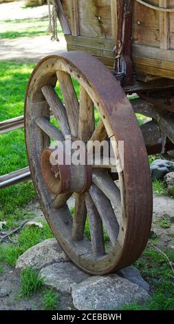 Primo piano della vecchia ruota di legno del carro coperto Foto Stock