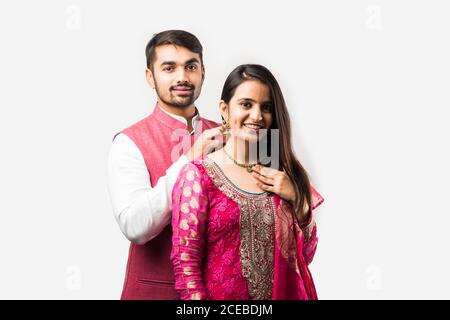 L'uomo indiano legando o presentando la collana d'oro alla sua bella moglie il compleanno, il giorno di San Valentino, l'anniversario o il festival di Diwali Foto Stock