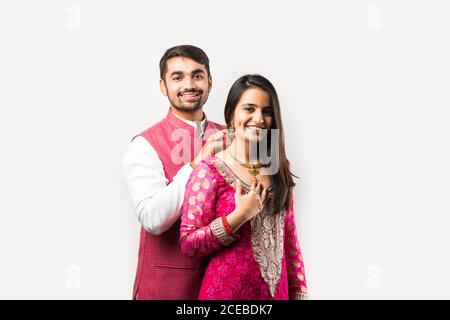 L'uomo indiano legando o presentando la collana d'oro alla sua bella moglie il compleanno, il giorno di San Valentino, l'anniversario o il festival di Diwali Foto Stock