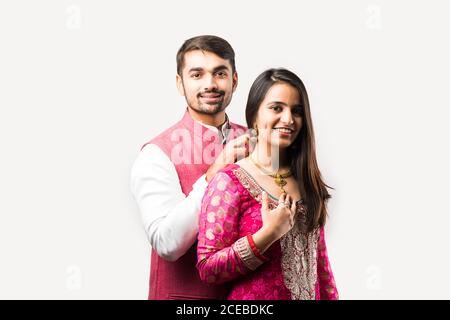 L'uomo indiano legando o presentando la collana d'oro alla sua bella moglie il compleanno, il giorno di San Valentino, l'anniversario o il festival di Diwali Foto Stock