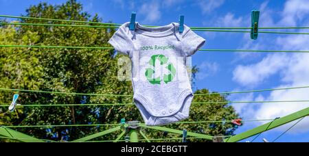 Riciclare l'icona vestiti su Babygro asciugare all'esterno sulla linea di lavaggio con il 100% di testo riciclato, sostenibile concetto di illustrazione di modo riutilizzo, riciclaggio clothing Foto Stock