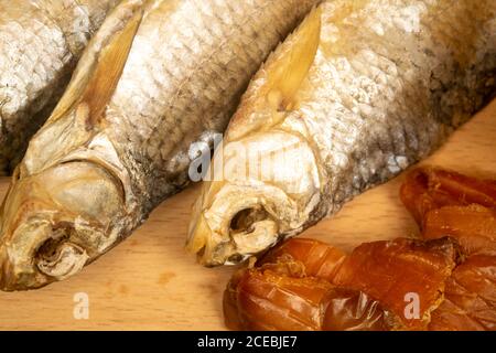 Pesce essiccato e caviale essiccato su una tavola di servizio di legno. Primo piano Foto Stock