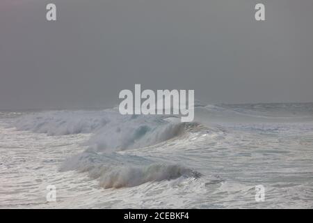 Grandi onde d'acqua salata che rotola in un mare tempestoso contro il cielo grigio vicino all'isola di Gran Canaria, Spagna Foto Stock