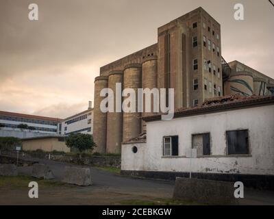 Belle vecchie pareti intemperie di edifici grigi struttura e vuoto strada in estate al tramonto Foto Stock