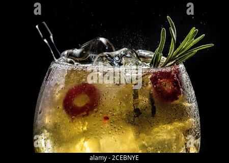 primo piano di gin tonico rosso frizzante con cetriolo e pepe Foto Stock