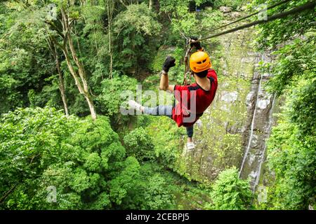 Freedom Adult Man Tourist indossare abbigliamento casual sulla zip Line O l'esperienza di tettoia Foto Stock