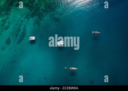 Vista aerea di piccole barche colorate e zattere che navigano in acque scure e profonde nella soleggiata giornata estiva a la Graciosa, Isole Canarie Foto Stock