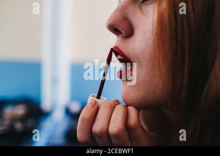 Labbra ruggenti di signora dai capelli rossi attraenti Foto Stock