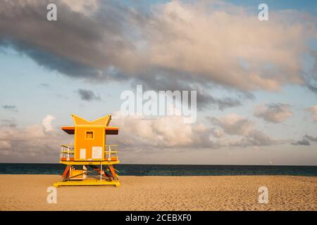 Piccola cabina salvavita in piedi sulla spiaggia di sabbia nel giorno nuvoloso A Miami Foto Stock