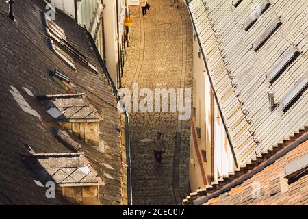 BRATISLAVA, SLOVACCHIA, 30 SETTEMBRE 2016: L'uomo cammina sulla strada acciottolata della città vecchia di Bratislava. Vista dall'alto. Vista rialzata dei tetti rossi Foto Stock