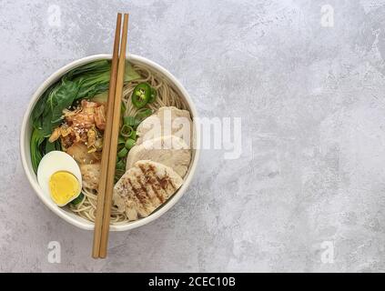 Tagliatelle asiatiche di Miso Ramen con uova, pollo e cavolo di pak Choi in ciotola. Foto Stock
