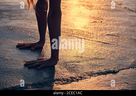 Armi di anonimo esercizio femminile su superficie di cemento ruvida durante il tramonto Foto Stock