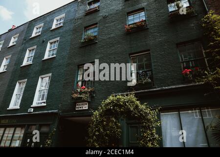 LONDRA, REGNO UNITO - 23 OTTOBRE 2018: Da sotto immagine di facciata di vecchio edificio residenziale in mattoni sulla strada di Londra, Inghilterra Foto Stock