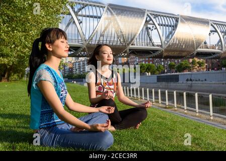 Le donne asiatiche meditano nel parco Foto Stock