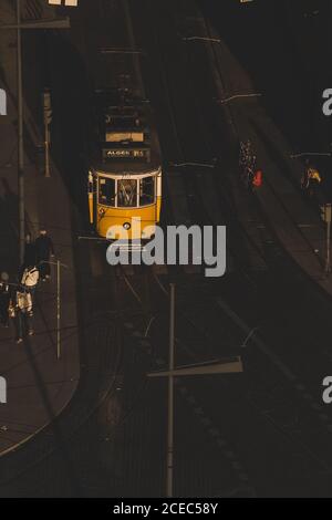 LISBONA, PORTOGALLO - 23 GENNAIO 2019: Dall'alto della moderna tramvia che conduce lungo la strada asfaltata della città con le persone sul marciapiede sotto la luce del sole Foto Stock