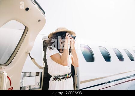 Pretty Woman abbassa un aeroplano all'aperto e scatta foto. Foto Stock