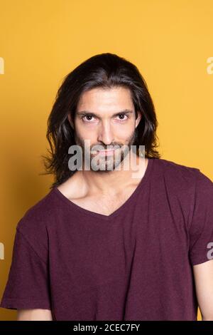 Bell'uomo sicuro che posa sulla parete gialla Foto Stock