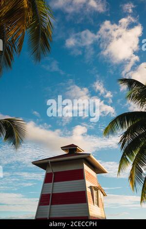 Spiaggia tropicale con piccolo faro di legno sul molo con case gialle in fila, Panama Foto Stock