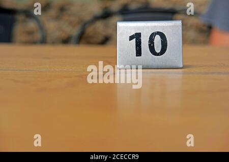 Tag numero dieci su un tavolo di legno in un ristorante Foto Stock