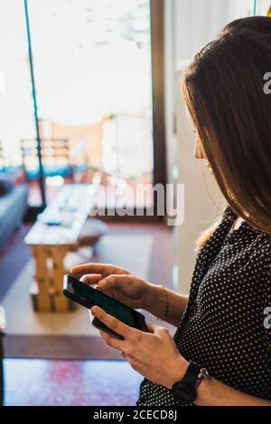Donna che utilizza il telefono di casa Foto Stock
