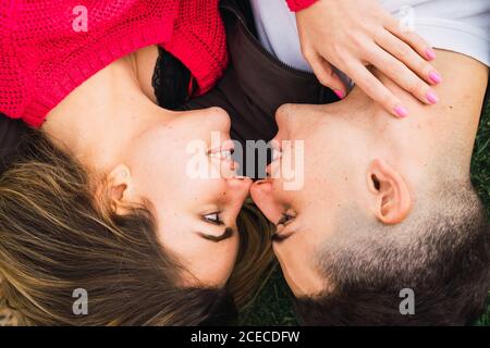 Felice coppia amorevole che posa sull'erba Foto Stock