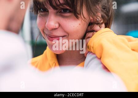 Primo piano di un giovane e una donna irriconoscibili che si baciano mentre si sono in piedi per strada Foto Stock