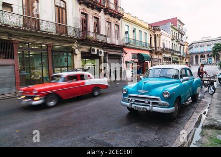 LA HABANA, CUBA - NOVEMBRE, 6 , 2018: Automobile d'epoca sulla strada vicino?building tra alberi e uomini in giornata di sole a Cuba Foto Stock