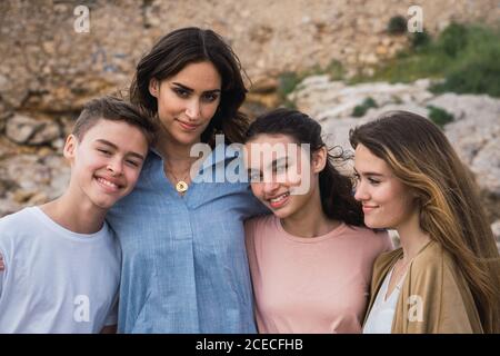 Giovani amici che ridono e si abbracciano insieme su sfondo mare Foto Stock