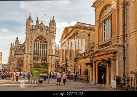 Abbazia di Bath e l'ingresso principale dei visitatori del romano Bagni nel cortile Abby nella città romana di Bath in Gran Bretagna Foto Stock