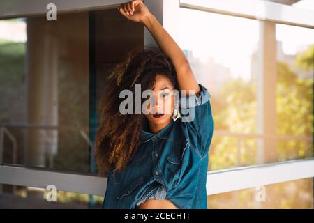 Donna afro-americana in piedi vicino al muro Foto Stock
