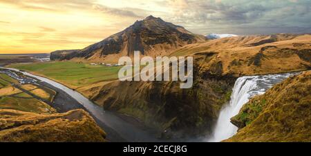 Vista aerea del paesaggio meraviglioso con le montagne texture e cascata sotto il cielo nuvoloso, Islanda. Foto Stock