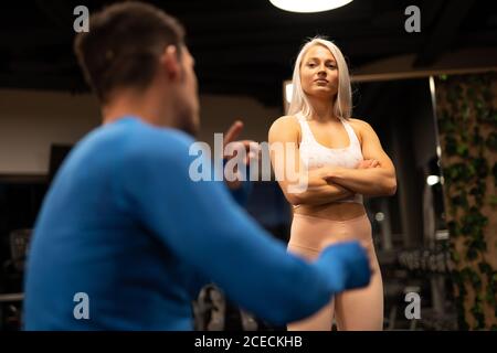 Donna e uomo che parla in palestra Foto Stock