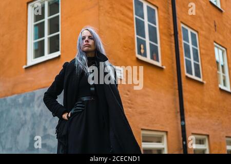 Vogue elegante Donna in cappotto nero in piedi e posa in strada città. Foto Stock