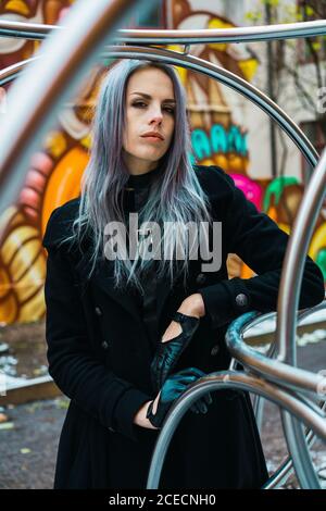 Donna in abiti caldi al muro dei graffiti Foto Stock