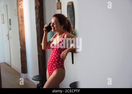 Giovane donna che usa lo smartphone e sorridente Foto Stock
