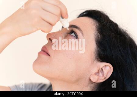 Concetto di visione. Giovane bella Donna con eyedrops. Foto Stock