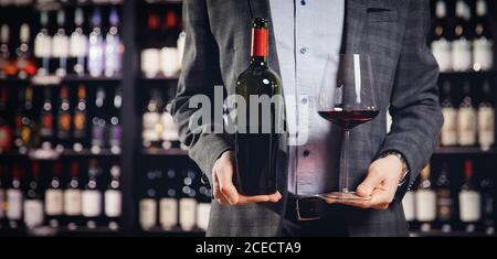 Sommelier del cameriere che versa il vino rosso in bicchiere. Spazio di copia Foto Stock