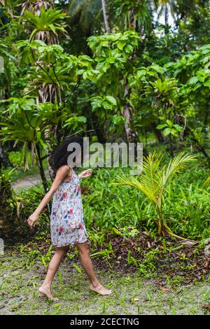 Giovane donna in abito tra foresta tropicale Foto Stock