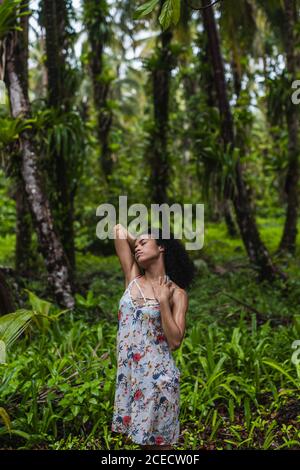 Giovane donna in abito tra foresta tropicale Foto Stock